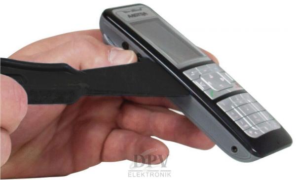 Eine Hand hält ein schwarzes Mobiltelefon. Ein Werkzeug zur Entfernung des Akkus ist auf der anderen Seite platziert. Die Hand und das Telefon sind im Fokus der Darstellung.