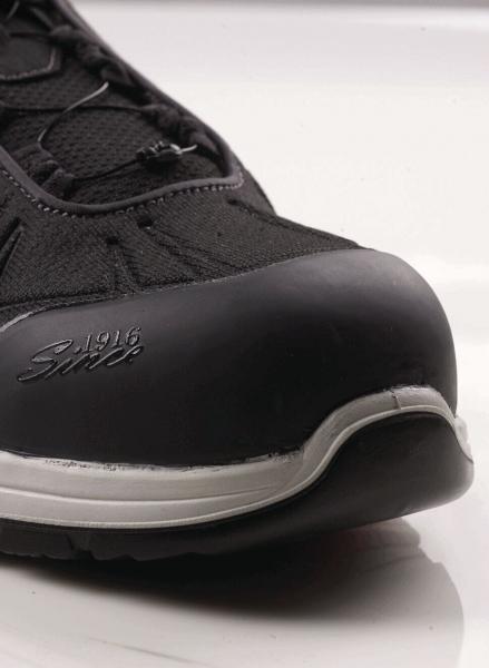 The image shows the front part of a black shoe with a sturdy rubber sole and a reinforced toe. The shoe has a textile upper and laces.