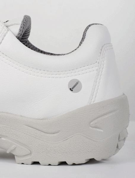 Das Bild zeigt die Seite eines weißen Sportschuhs mit grauem Sohlenteil. Der Schuh hat eine glatte Oberfläche, mit einer kleinen runden Markierung. Der Innenbereich ist leicht grau und gepolstert.