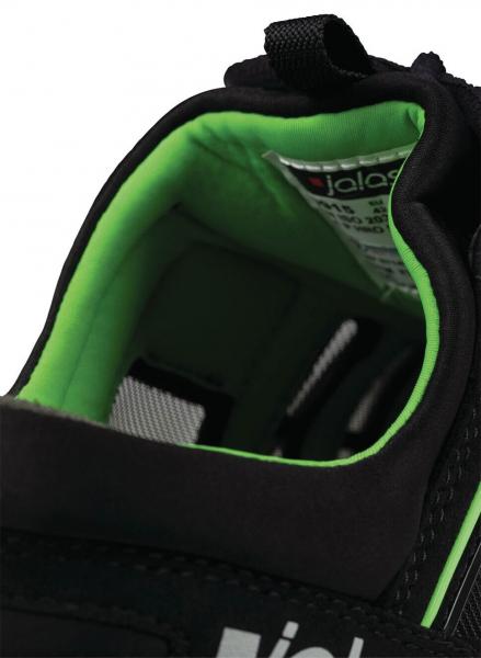 The image shows the interior of a black shoe with green lining. The sole is well-cushioned and provides comfort. A label with information is visible.