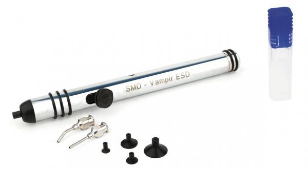 The image shows a silver tool with a black tip and several attachments in different shapes. Next to it is a transparent container with a blue cap.