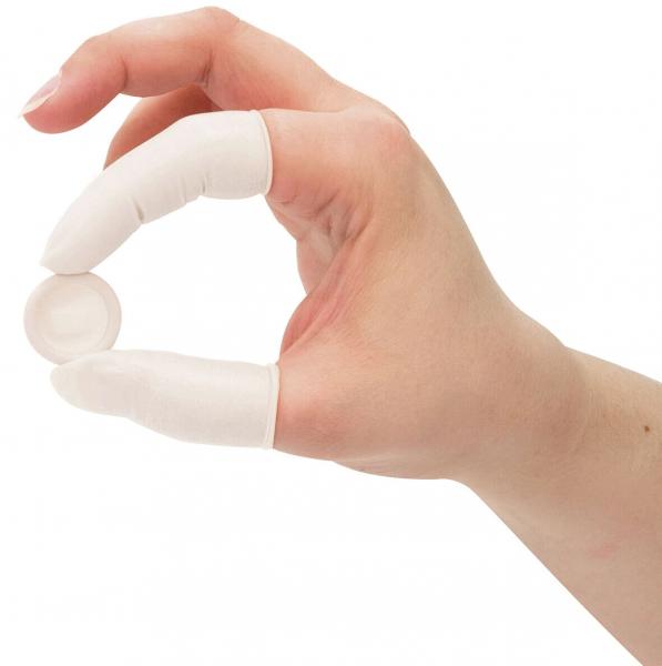 Eine Hand mit weißen Handschuhen hält eine kleine, runde Scheibe zwischen Daumen und Zeigefinger. Die Hand ist nach vorne gerichtet.