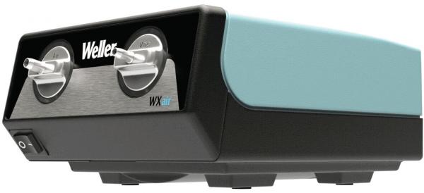 The image displays a black and turquoise device with two round knobs on the front. It reads