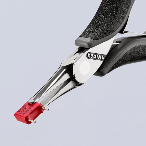 The image shows a pair of pliers with a non-slip grip. On the slender, long jaws of the pliers, there is a red, rectangular object. The background is light and solid.