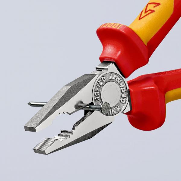 Das Bild zeigt eine Zange mit rot-gelben Kunststoffgriffen. Die Zangenspitze ist flach und hat eine geriffelte Oberfläche. Ein Metallstift liegt zwischen den Backen.