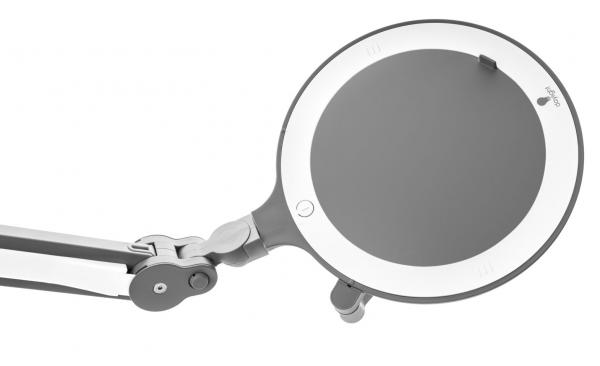 The image shows an adjustable magnifying glass with a round glass part and a white rim. It is attached to a flexible arm, which is used to adjust the position.