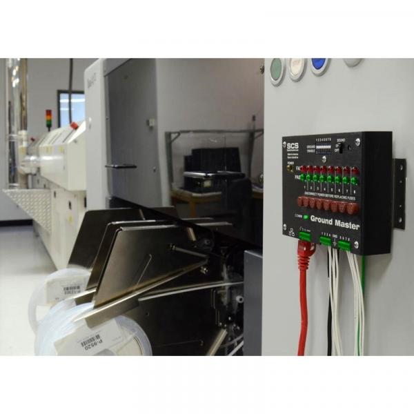 The image shows a technical environment with a device named "Ground Master". It has numerous green LEDs and connection cables in various colors. To the left, a larger machine is visible.