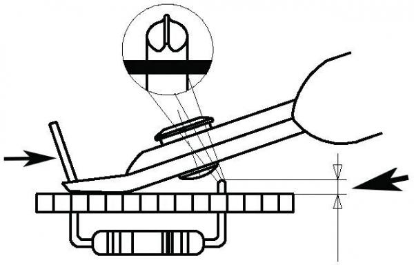 The image shows a technical drawing with a hand holding a tool that presses on a schematic representation of a circuit board. Above is an enlarged view of a component.