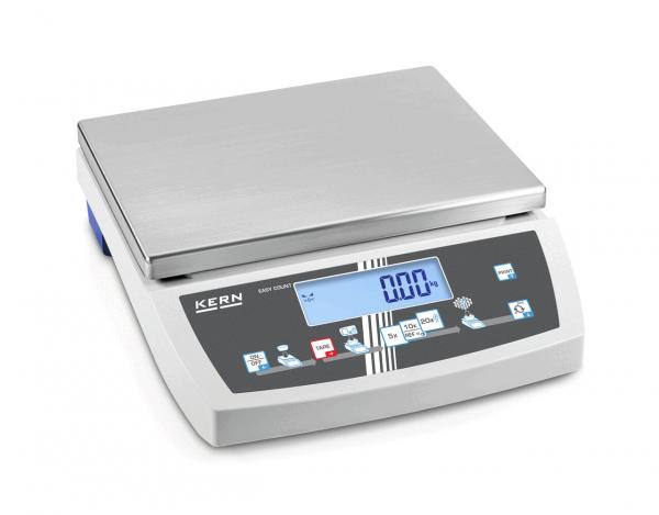 The digital scale has a flat, rectangular stainless steel surface on top. Beneath it is a display with blue digits and control buttons in various colors.