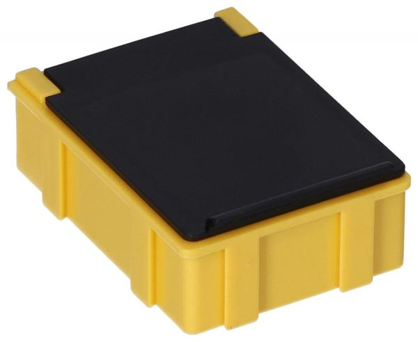Es handelt sich um eine kleine, quadratische Box. Die Unterseite ist leuchtend gelb und hat eine strukturierte Oberfläche, während der Deckel schwarz und glatt ist. Die Kanten sind abgerundet.
