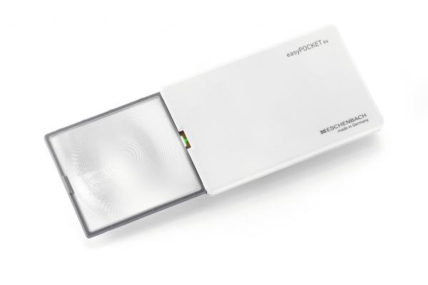 Das Bild zeigt eine handliche Lupe mit einem rechteckigen Gehäuse in Weiß. Die Linse ist leicht konvex und enthält ein integriertes Licht. Sie dient zur besseren Sichtbarkeit von kleinen Texten oder Details.