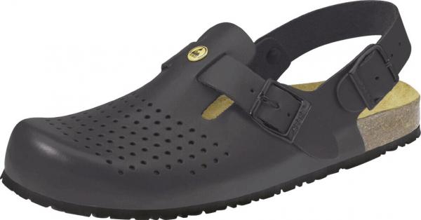The image shows a black plastic clog shoe with ventilation holes. It has an adjustable strap over the instep and a light-colored insole. The sole is slip-resistant.