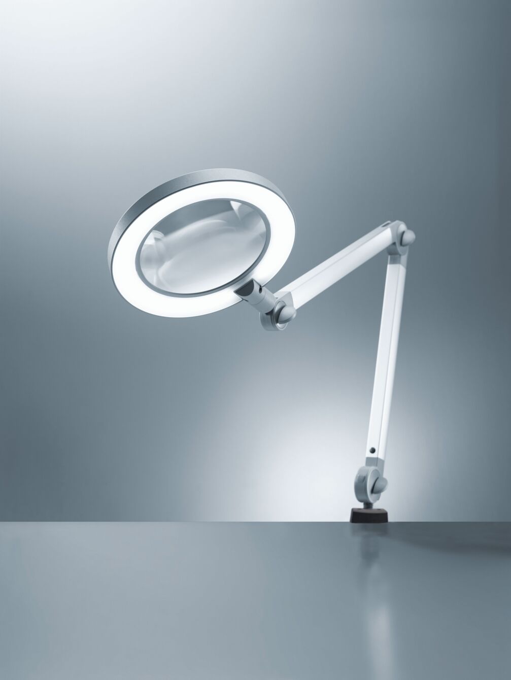 The image displays a feature-rich magnifying glass with light, mounted on a flexible, white arm. The round lamp edge ensures even illumination. The background is simple and bright.