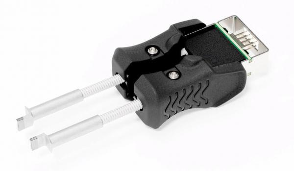 Das Bild zeigt einen Adapter mit zwei silbernen Stiften und einem schwarzen, ergonomisch geformten Griff. Der obere Teil hat einen Anschluss, der an einen USB-Port erinnert.