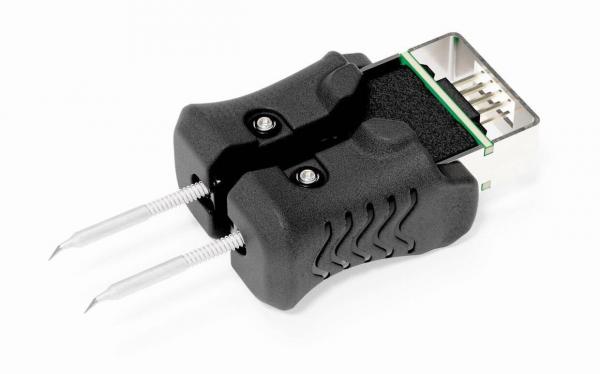 The image shows an electrical adapter with two long, thin metal pins and a plastic handle. The handle has a textured surface and is located in the center. A USB port is visible at the top.