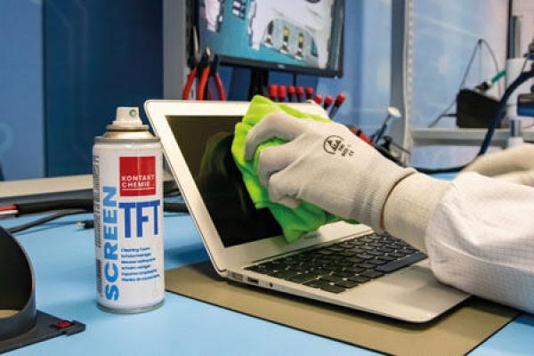 The image shows a laptop screen being cleaned with a green cloth. Next to it is a spray can labeled "SCREEN TFT". The table has a blue surface and tools in the background.