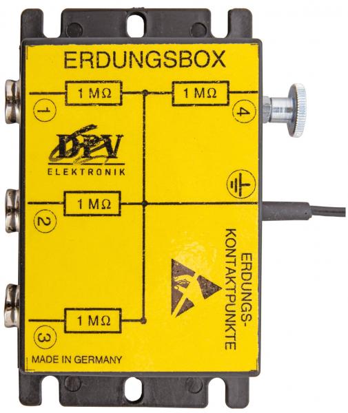 It is a yellow electronics box labeled "Grounding Box" with various connections. It has four 1 MΩ contacts, an adjustment element, and a marking for grounding points.