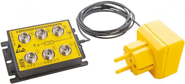 The image shows a yellow junction box with six round sockets and a cable. Next to it is a yellow power plug with two flat prongs.