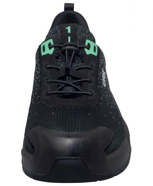 Der Schuh ist schwarz mit leicht glänzenden, strukturierten Oberflächen. Er hat grüne Schnürsenkel und einen stabilen, runden Vorderteil. Die Sohle ist robust und gut gepolstert.