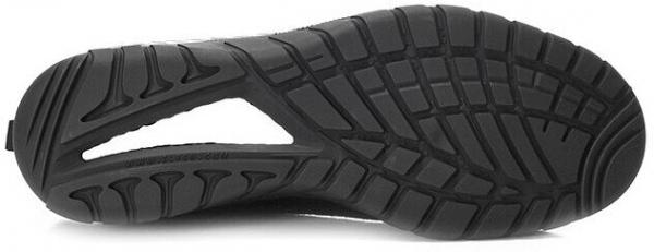 The image shows the underside of a black sports shoe. The sole features a non-slip pattern with deep grooves and tread, providing good grip.