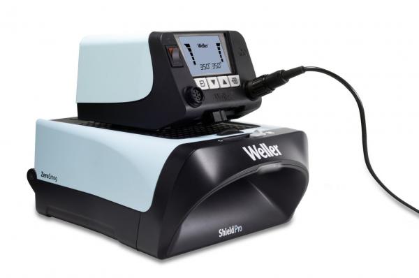 The image shows an electronic device in black and light blue with a display, buttons, and an attached cable. It appears to be a soldering station or a similar tool.