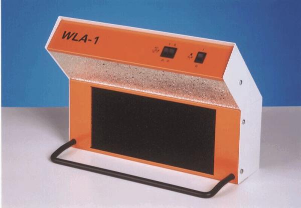 The image shows a device with a slanted top surface. It has an orange front and a black, textured area underneath. Control knobs are located on the side.