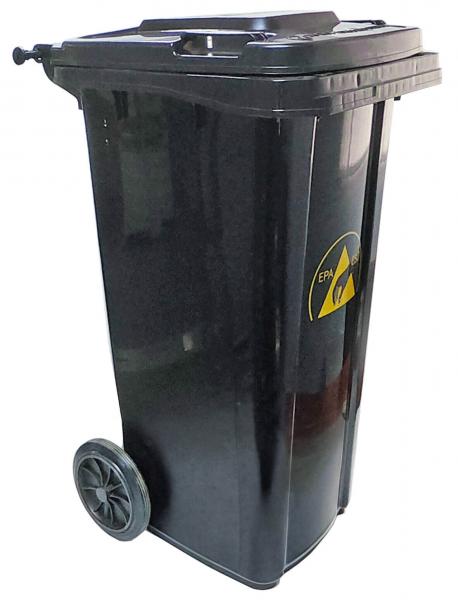 The garbage container is black, has two wheels for movement, and a removable lid. On the front, there is a warning sign with a yellow triangle.