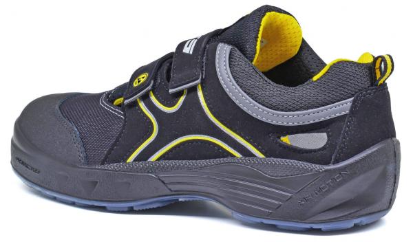 The shoe is sporty, with a black and gray surface. Yellow accents along the sides and on the inner edge. It has a Velcro closure and a sturdy sole.
