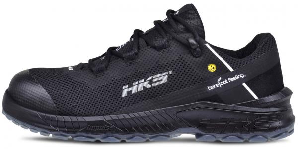 Der Schuh ist ein leichter, schwarzer Sportschuh mit einem luftigen Obermaterial. Er hat eine schwarze Sohle und ein schlichtes Design mit einem weißen Streifen und einem gelben Logo.