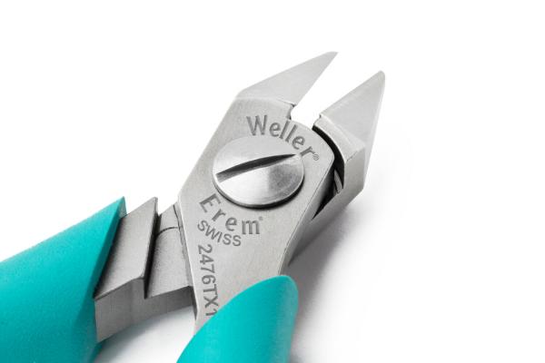 The image displays an elegant, silver tong with pointed, sharp blades. The handles are in a bold turquoise, and the tong is precisely crafted.