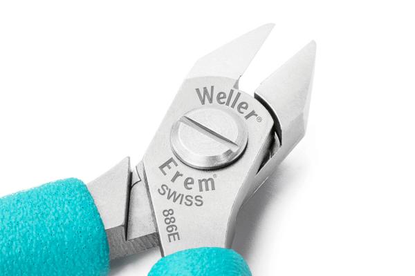 The image displays a high-quality pair of pliers with two sharp, pointed metal blades. The handle is coated with a blue rubber surface. Brand names are embossed on the pliers.