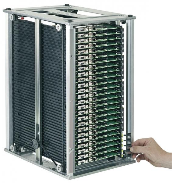 The image shows a rectangular metal device bay with several vertically arranged green circuit boards. A hand reaches for the left side of the device.