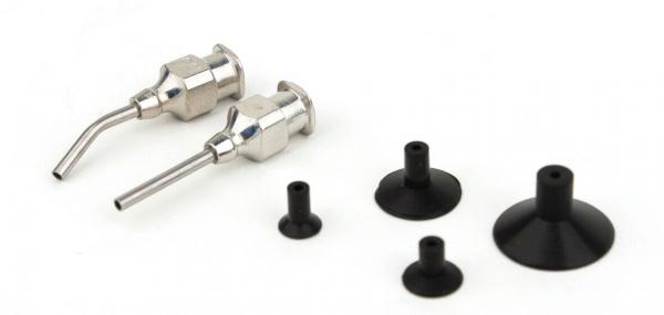 The image shows two metallic spray nozzles next to several rubber-like, black attachments in various sizes and shapes. They are arranged on a white surface.