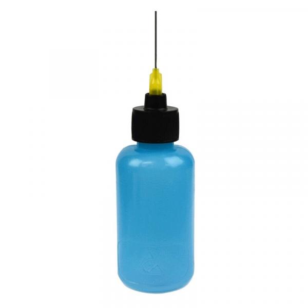 The image shows a bottle that is blue and has a black cap. A thin metal nozzle with a yellow tip protrudes from the cap. The bottle has a round shape.