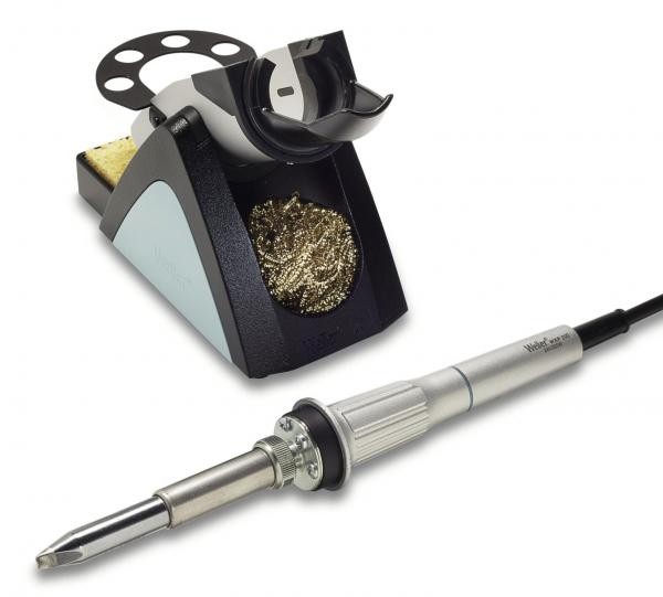 The image shows a soldering iron with a gray handle and a pointed soldering tip. Next to it is a soldering iron stand with a metal cleaning spiral and a sponge area.