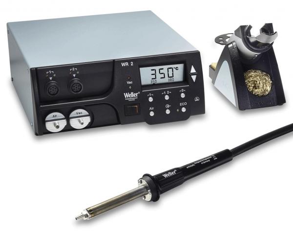 The image displays a soldering device with a digital temperature display. Next to the device, there is a soldering iron with a long cable and a soldering station. The predominant colors are grey and black.