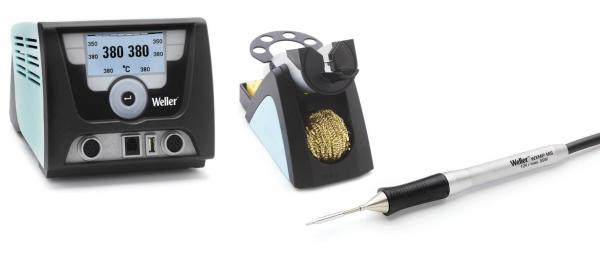 The image displays a soldering iron kit. On the left is a digital soldering iron controller with a display, on the right a soldering iron and a holder with a wire brush.
