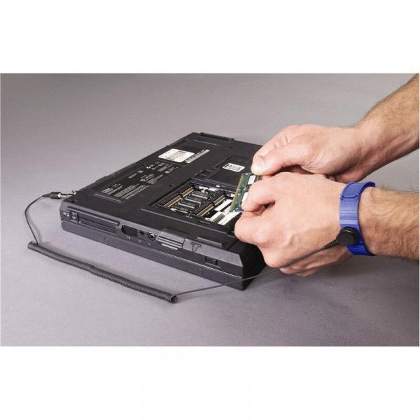 Das Bild zeigt einen Laptop von der Unterseite. Eine hand greift nach einem Bauteil, das aus dem Laptop herausgenommen wird. Der Laptop ist schwarz, mit sichtbaren Anschlüssen.
