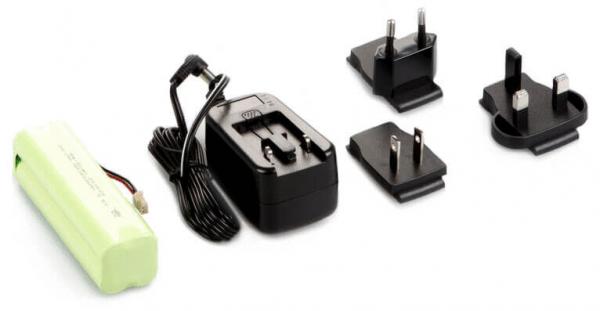 In the picture, there is a green battery module, a black charger with a cable, and three different plug adapters. The adapters are designed in various shapes.