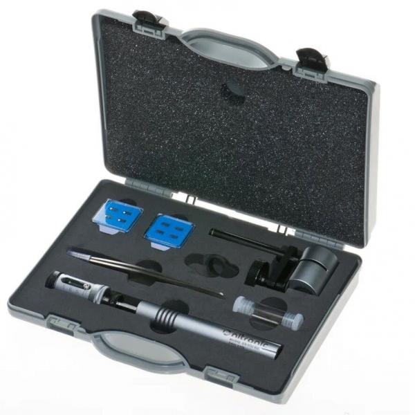The image displays a toolbox with various instruments. The box is gray and features a foam insert. Included are a screwdriver, two blue parts, and additional small tools.