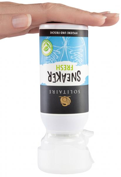 The image shows a hand holding a bottle labeled "SNEAKERS FRESH." The bottle has a white cap and a large blue imprint that promises fresh shoe care.