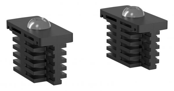 Das Bild zeigt zwei rechteckige schwarze Bauteile mit einer kuppelförmigen Oberseite. Sie haben mehrere schmale, horizontale Rillen auf der Vorderseite und sind symmetrisch gebaut.