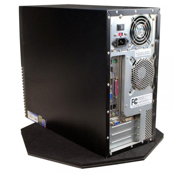 The image displays the casing of a computer. It is black with a silver back that features various ports and ventilation slots. The computer is situated on a plated base.