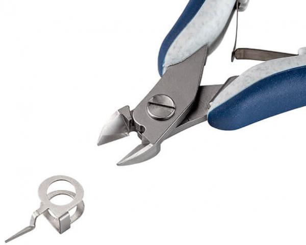 In the picture, there are pliers with blue handles and a small metal eyelet. The pliers have sharp blades for cutting. The eyelet is lying next to it.
