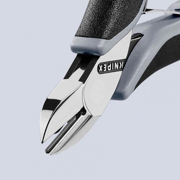 The image displays the precise tip of a pair of pliers with shiny blades and an ergonomic, gray handle. The word "KNIPEX" is printed on the pliers.