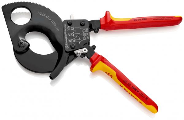 The image shows a large, black cable cutter with red and yellow handles. The cutter has a round opening on the left side and a lever mechanism in the center.