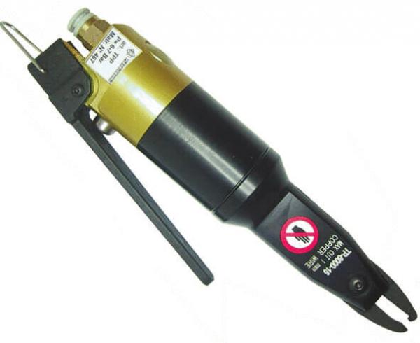 The image shows a black and gold tool with a long, slender body and a trigger. At one end, there is an opening intended for compressed air. A warning symbol is visible.