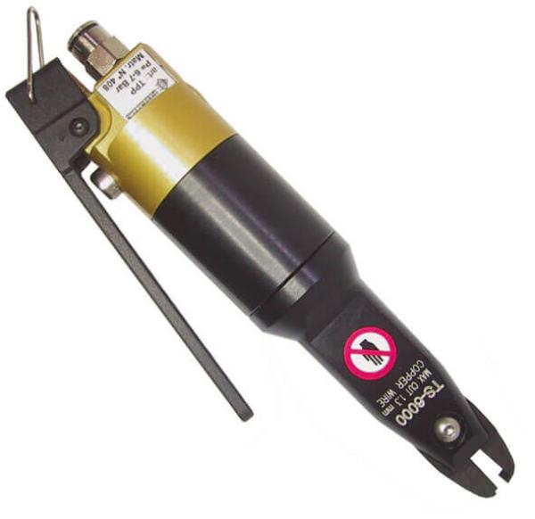 The image shows a device that looks like a tool. It has a long, cylindrical body that is black and gold, with an attachment and a warning label.