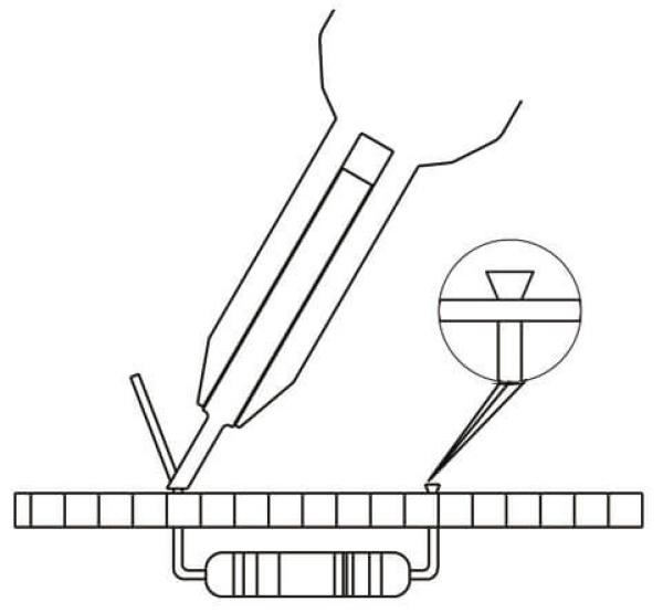 The image shows a technical setup: A pair of tweezers holds a small component above a plastic circuit board. A magnifying glass enlarges the component that is being placed on the board.