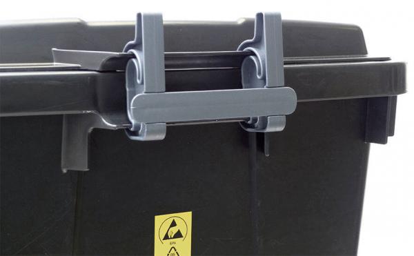 The image shows a black trash can with a movable lid. The lid is secured by two gray clips attached to the sides. A warning symbol is visible.